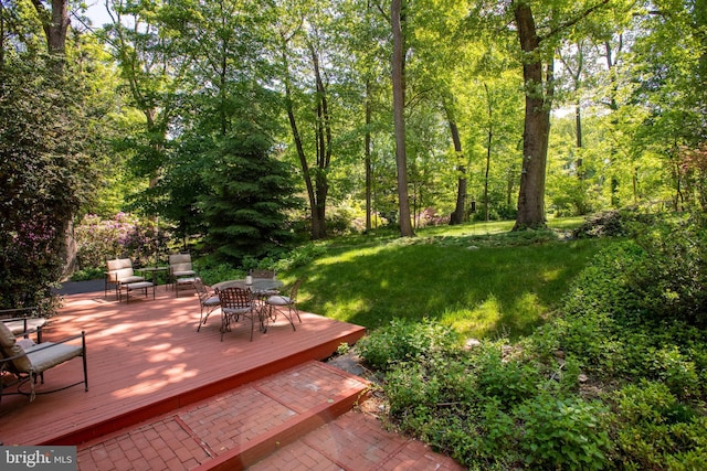 view of yard with outdoor dining area and a wooden deck