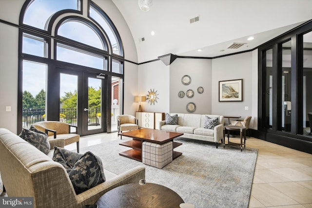 interior space featuring light tile patterned floors, a high ceiling, visible vents, and french doors