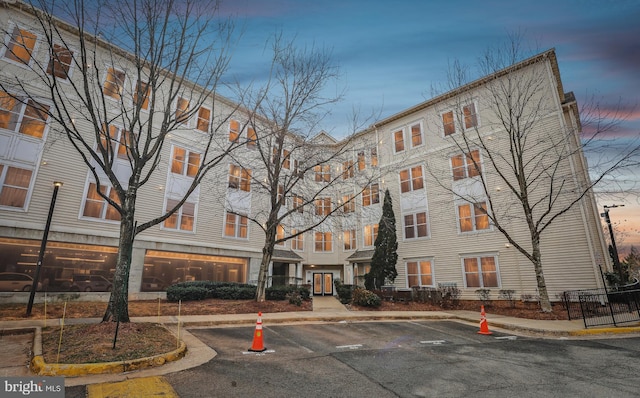 property at dusk featuring uncovered parking