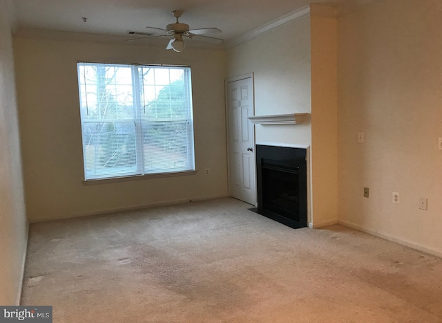 unfurnished living room featuring ceiling fan, a healthy amount of sunlight, light colored carpet, and ornamental molding