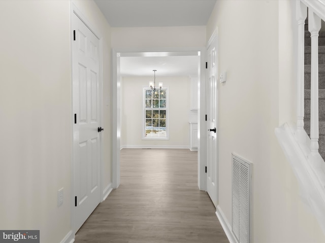 hall with a notable chandelier and hardwood / wood-style floors