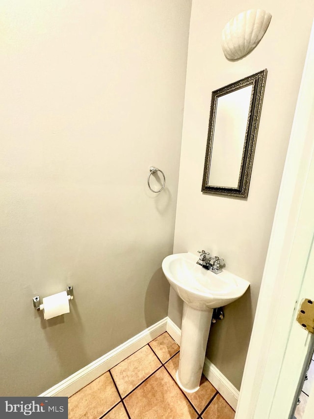 bathroom featuring baseboards, a sink, and tile patterned floors