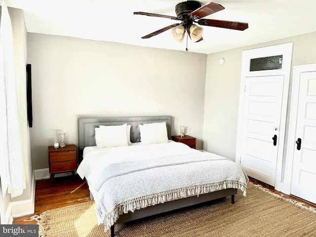 bedroom with a ceiling fan, baseboards, and wood finished floors