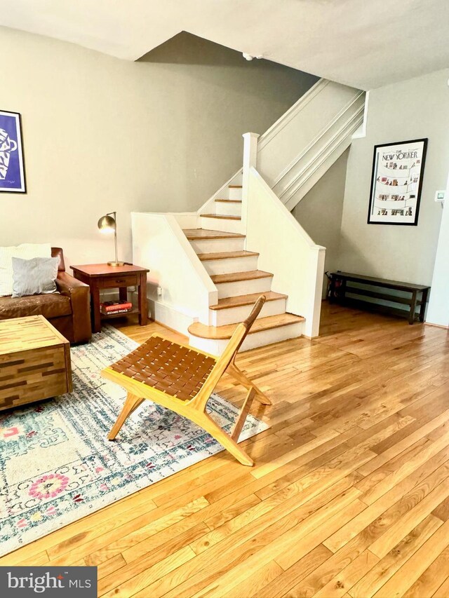 living area featuring stairway and wood finished floors