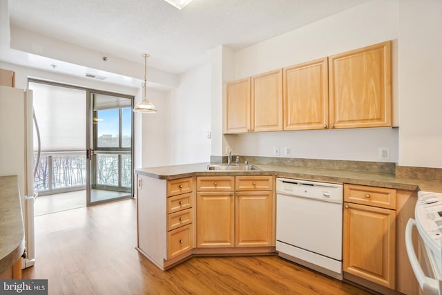 kitchen featuring sink, light hardwood / wood-style flooring, white appliances, and decorative light fixtures