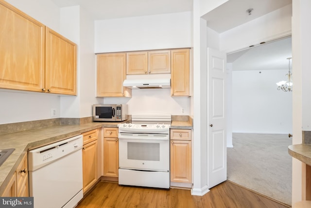 kitchen featuring white appliances, light hardwood / wood-style flooring, an inviting chandelier, decorative light fixtures, and light brown cabinets