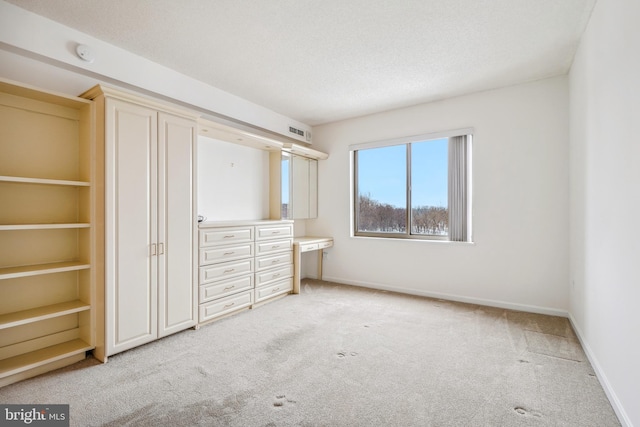 unfurnished bedroom with light carpet and a textured ceiling