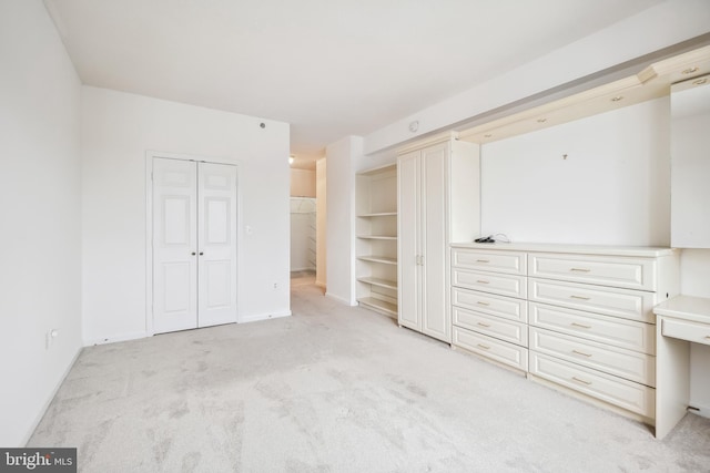 unfurnished bedroom featuring light colored carpet and a closet