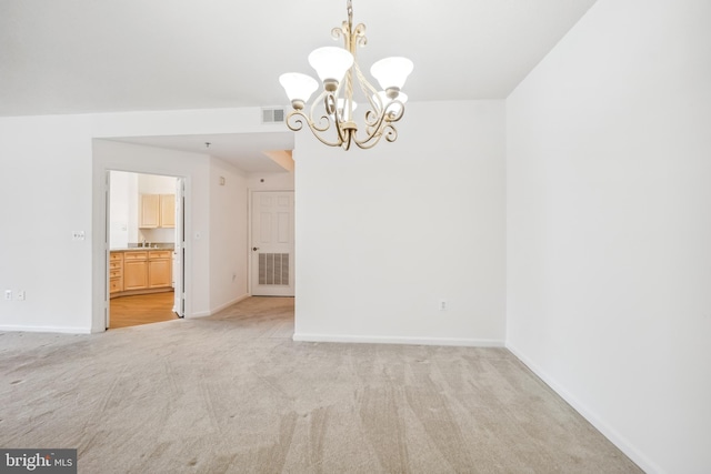 unfurnished dining area with an inviting chandelier and light colored carpet