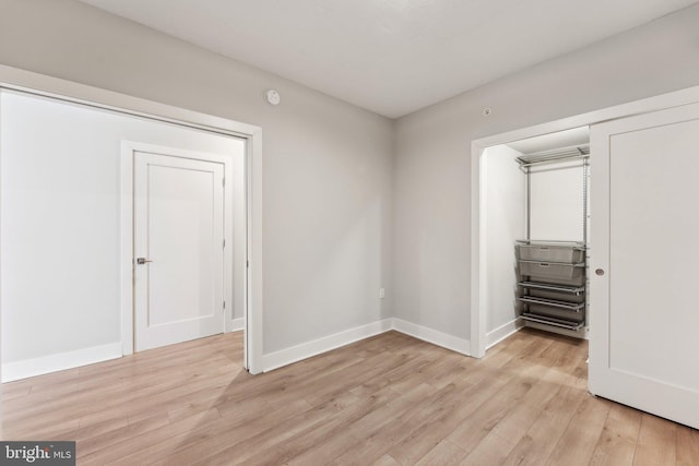 unfurnished bedroom featuring a closet and light wood-type flooring