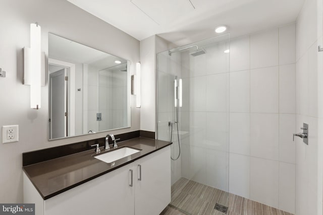 bathroom with vanity and tiled shower