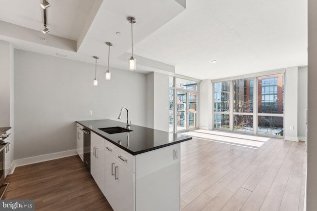 kitchen featuring sink, stainless steel appliances, white cabinetry, expansive windows, and pendant lighting