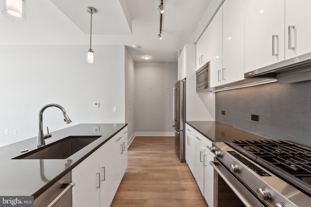 kitchen featuring sink, decorative light fixtures, white cabinets, and appliances with stainless steel finishes