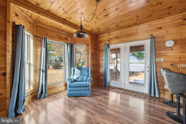 sitting room featuring hardwood / wood-style flooring, wooden ceiling, and wood walls