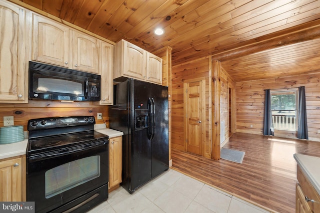 kitchen with black appliances, wood ceiling, light brown cabinetry, wood walls, and light tile patterned flooring