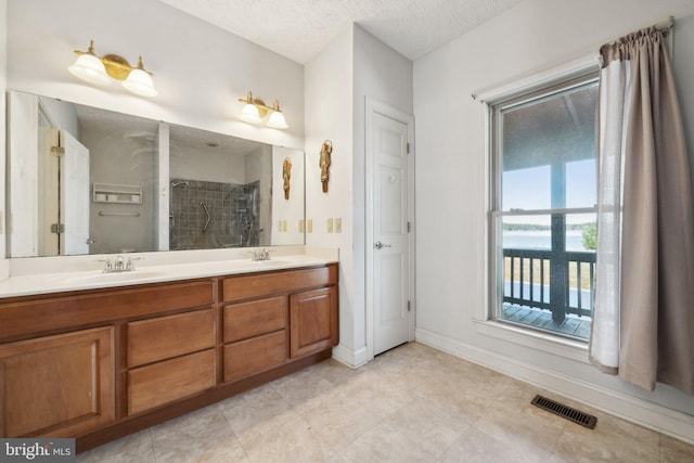 bathroom featuring a textured ceiling, a shower, and vanity