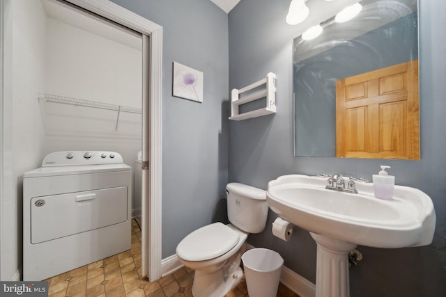 bathroom featuring toilet, tile patterned flooring, and washer / clothes dryer