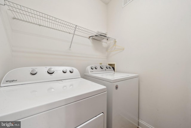 clothes washing area featuring separate washer and dryer