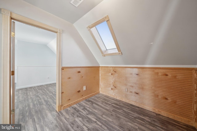 bonus room with wood-type flooring and lofted ceiling with skylight