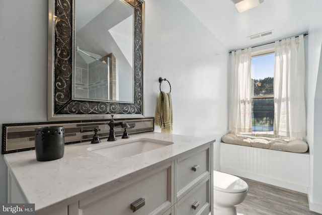 bathroom with toilet, vanity, tasteful backsplash, lofted ceiling, and wood-type flooring