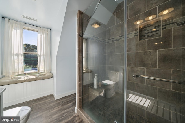 bathroom with toilet, lofted ceiling, hardwood / wood-style floors, and walk in shower