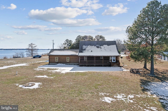 view of front of home with a front lawn and a water view