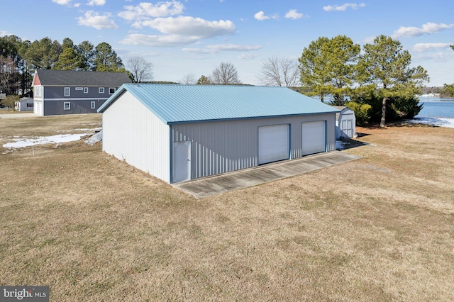 garage with a yard and a water view