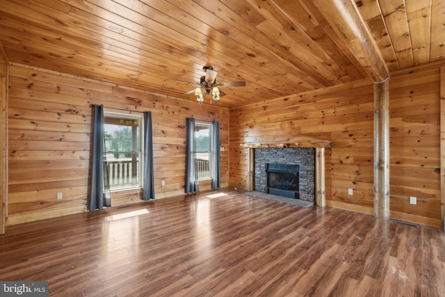 unfurnished living room featuring a stone fireplace, wood walls, and wooden ceiling