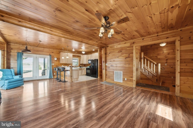 unfurnished living room featuring light hardwood / wood-style flooring, wooden walls, and wooden ceiling