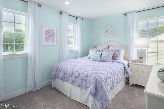 carpeted bedroom featuring multiple windows