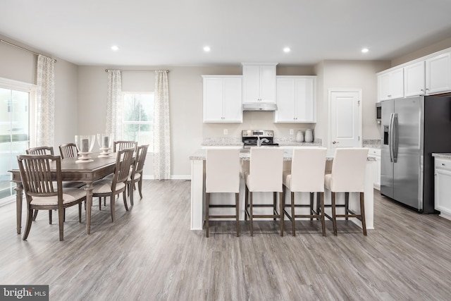 kitchen with white cabinetry, appliances with stainless steel finishes, and a kitchen island with sink