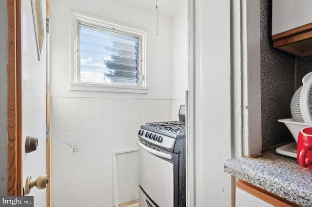 kitchen with gas stove and light stone countertops