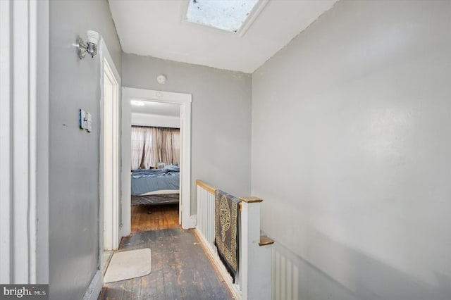 hallway featuring dark hardwood / wood-style flooring and a skylight