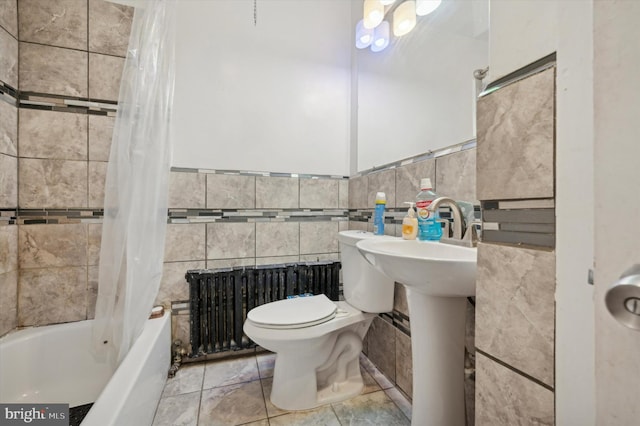 bathroom featuring tile walls, toilet, shower / bath combo with shower curtain, and radiator