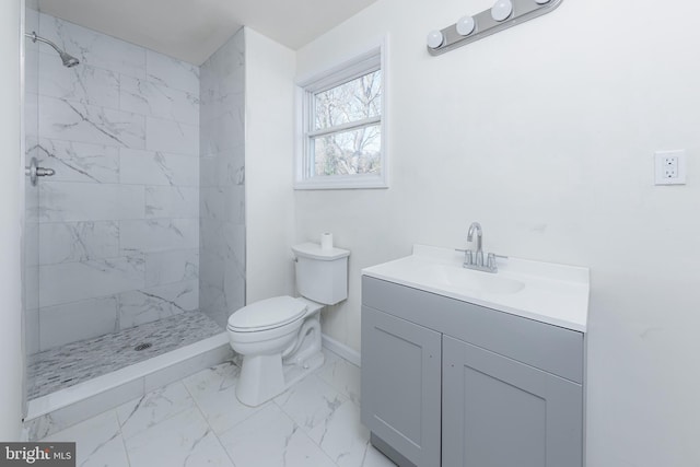 bathroom featuring toilet, tiled shower, and vanity