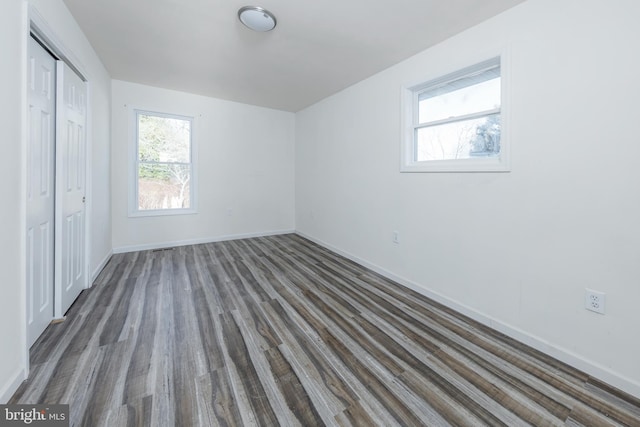 unfurnished bedroom featuring a closet and dark hardwood / wood-style flooring