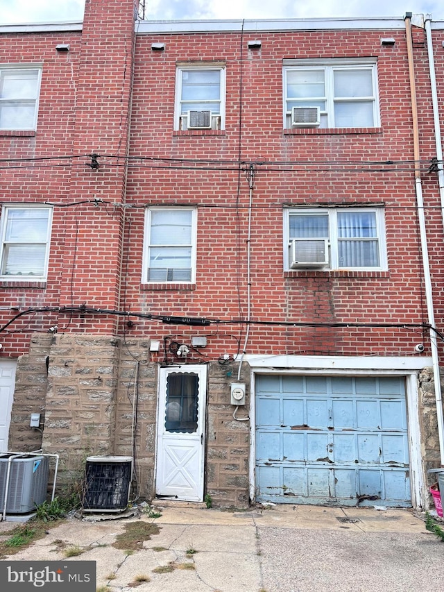 view of building exterior with cooling unit and a garage