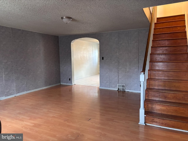 empty room featuring a textured ceiling and hardwood / wood-style flooring