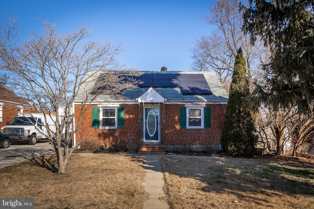 view of front of home featuring a front yard and solar panels