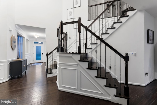 staircase featuring wood-type flooring and ornamental molding