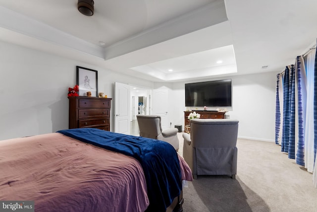 bedroom with a tray ceiling, ornamental molding, and light carpet