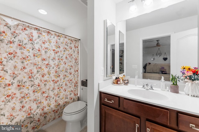 bathroom with toilet, ceiling fan, vanity, and curtained shower