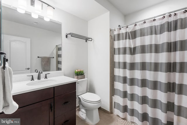 bathroom with toilet, walk in shower, and vanity