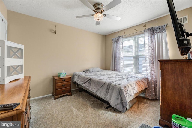 bedroom featuring ceiling fan, light carpet, and a textured ceiling