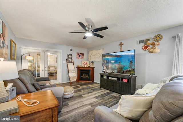 living room featuring french doors, a textured ceiling, hardwood / wood-style floors, and ceiling fan