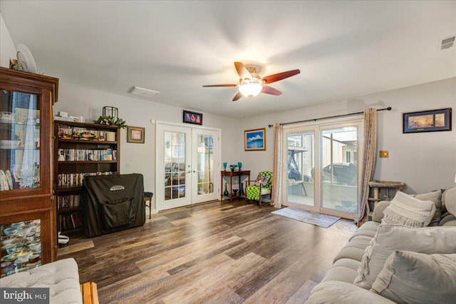 living room with ceiling fan, french doors, and dark hardwood / wood-style flooring