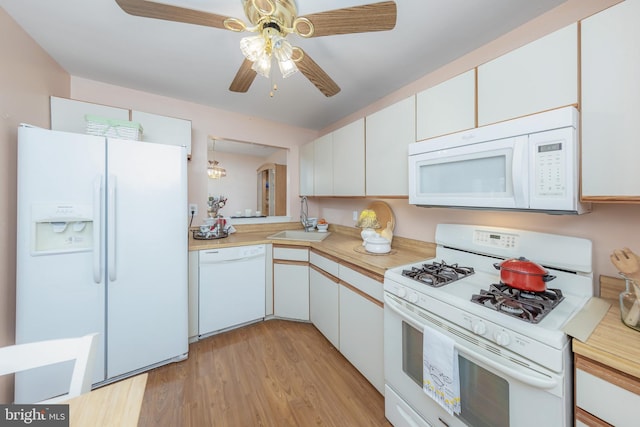 kitchen featuring white appliances, light hardwood / wood-style floors, white cabinets, and sink