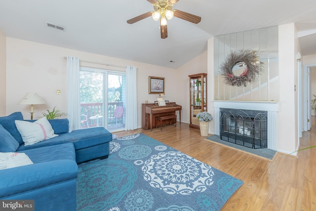 living room featuring lofted ceiling, hardwood / wood-style flooring, and ceiling fan