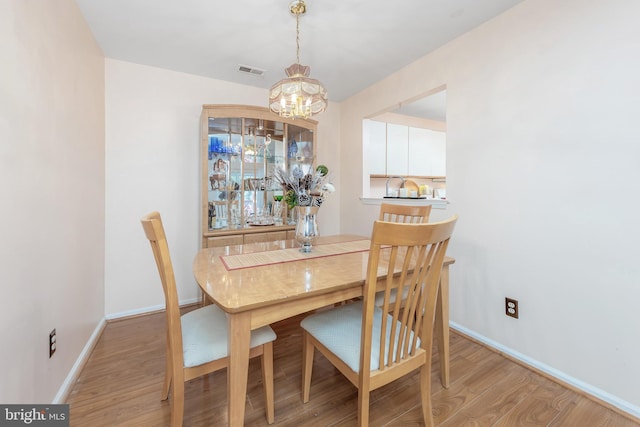 dining area featuring light hardwood / wood-style floors and an inviting chandelier