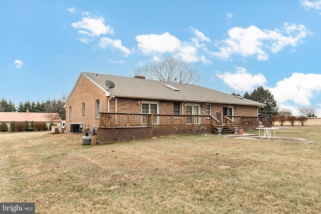 rear view of house with a wooden deck, a yard, and central AC unit